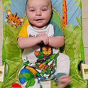 Axl joined the competition — help win amazing prizes! baby, child, infant, smiling, clapping, baby_chair, colorful, animal_pattern, giraffe, tiger, frog, parrot, playful, clothing, onesie, cartoon, green, yellow, happy, indoor