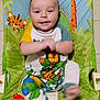 baby, child, infant, smiling, clapping, baby_chair, colorful, animal_pattern, giraffe, tiger, frog, parrot, playful, clothing, onesie, cartoon, green, yellow, happy, indoor