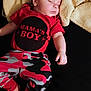 apparel, baby, blanket, camo_pants, casual, child, closeup, cozy, cute, human, indoors, infant, one_person, peaceful, portrait, red_shirt, resting, sleeping, soft_texture, toddler