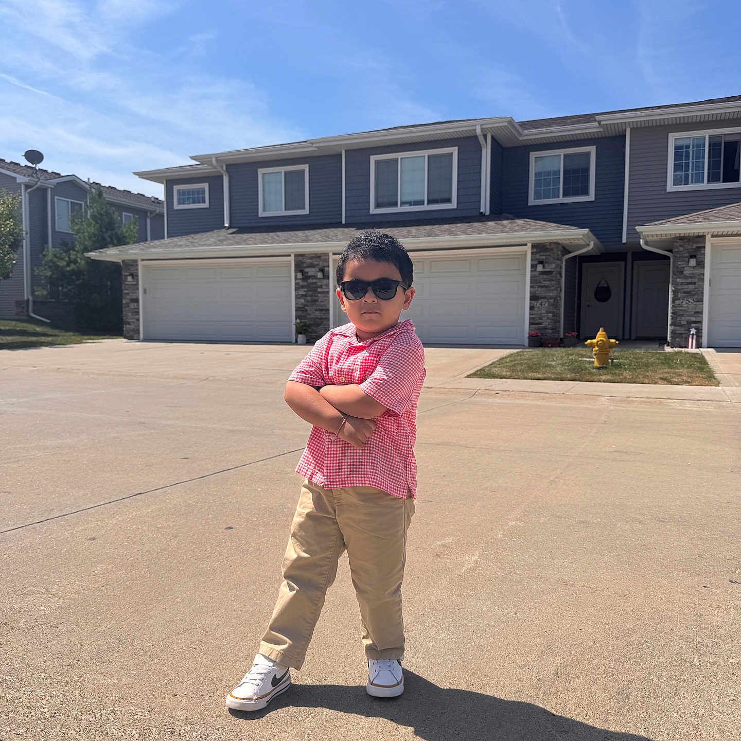 Oviyan joined the competition — help win amazing prizes! child, boy, sunglasses, posing, street, suburban, house, driveway, fire_hydrant, sunny, shadow, casual_clothing, short_sleeve_shirt, pants, sneakers, outdoor, confident, standing, person, daytime