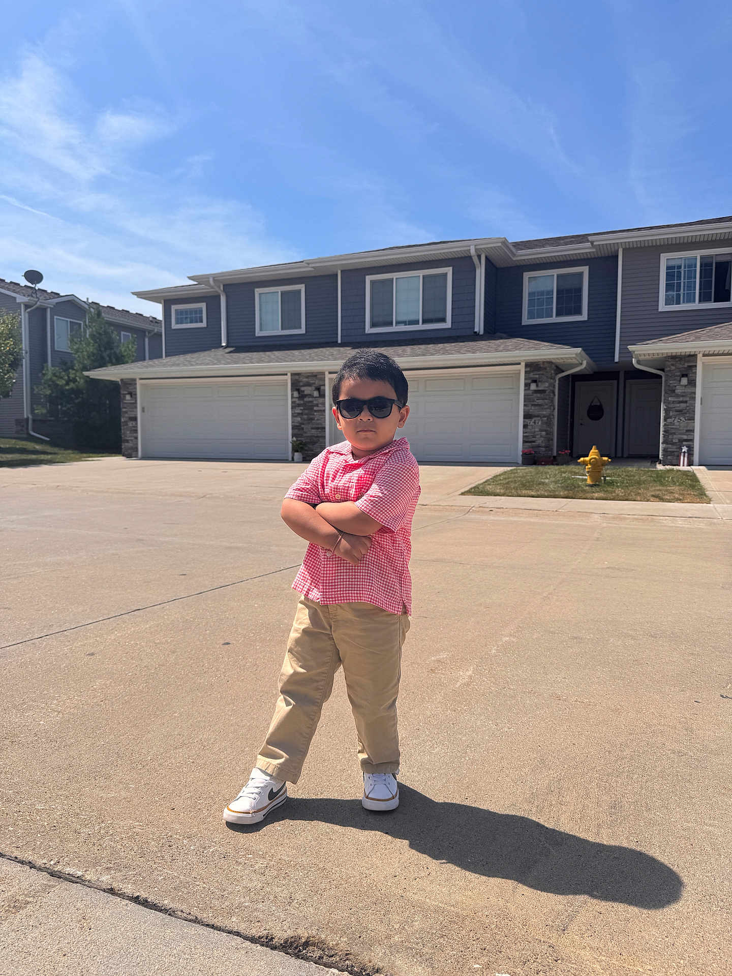 Oviyan joined the competition — help win amazing prizes! child, boy, sunglasses, posing, street, suburban, house, driveway, fire_hydrant, sunny, shadow, casual_clothing, short_sleeve_shirt, pants, sneakers, outdoor, confident, standing, person, daytime