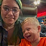candid, casual, ceiling_fan, chair, child, family, fun, glasses, green_hair, happy, indoor, joy, laughing, orange_shirt, people, portrait, restaurant, smiling, together, woman