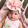 baby, infant, pink, headband, bow, blanket, clothing, face, portrait, cute, soft, texture, wood, tank_top, logo, lying_down, child, skin, expression, adorable