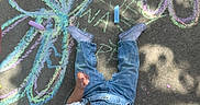 Zoey joined the competition — help win amazing prizes! toddler, child, chalk, sidewalk, drawing, flower, colorful, chalk_sticks, jeans, white_shirt, sneaker, outdoor, play, art, concrete, curly_hair, hand, expression, shoes, sunlight