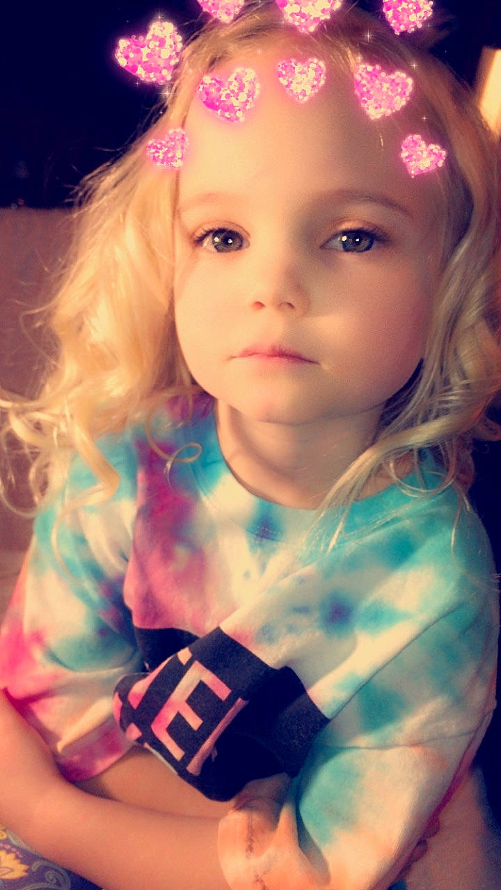 Josie is registered to the contest to win money with this photo: beauty, blond, brown_hair, cheek, child, child_model, eye, fun, girl, hair_accessory, human_hair_color, iris, long_hair, person, pink, skin, smile, toddler