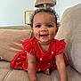 baby, child, crawling, red_dress, smiling, happy, indoor, couch, pillow, lamp, curly_hair, person, skin, furniture, home, cute, young, portrait, infant, bright