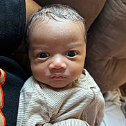 Kendrick is registered to the contest to win money with this photo: baby, babywearing, child, clothing, cute, expression, eyes, face, head, human, indoors, infant, newborn, onesie, person, portrait, skin, soft, striped, young