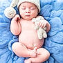 baby, sleeping, knitted_hat, pom_pom, blue_blanket, fluffy, newborn, cute, teddy_bear, soft, peaceful, infant, child, hand, foot, skin, portrait, cozy, resting, adorable