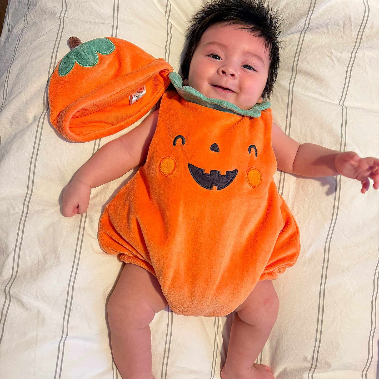Aegon joined the competition — help win amazing prizes! baby, bed, celebration, child, costume, cute, cute_outfit, festive, happy, hat, holiday, indoors, infant, lying_down, orange, portrait, pumpkin_costume, smiling, soft_fabric, striped_bedspread