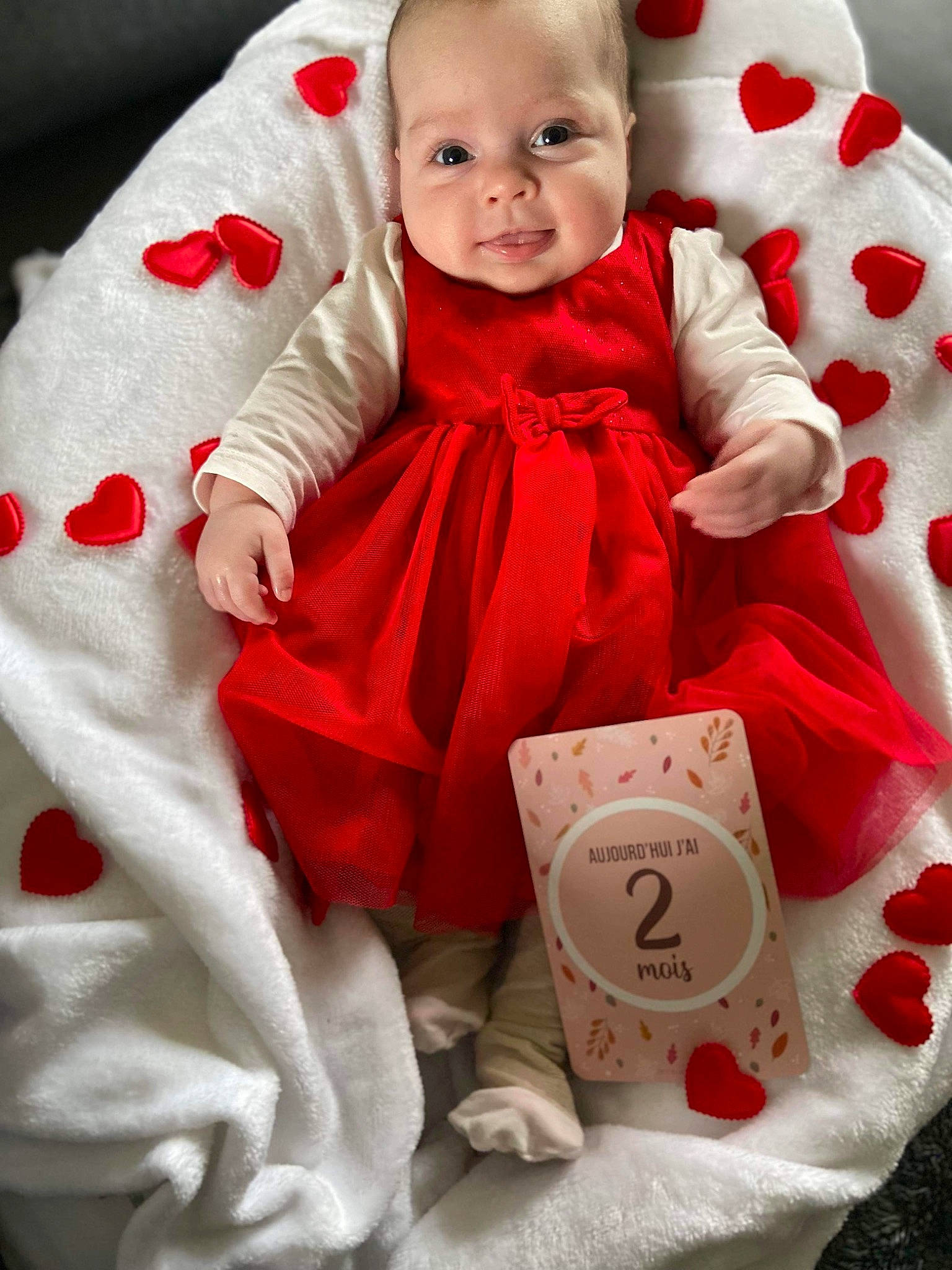 Mya a rejoint le concours — aidez-le/la à gagner de superbes lots ! baby, baby_products, baby_toddler_clothing, carmine, cheek, child, event, face, happy, holiday, pattern, person, pink, product, red, skin, sleeve, smile, sock, toddler