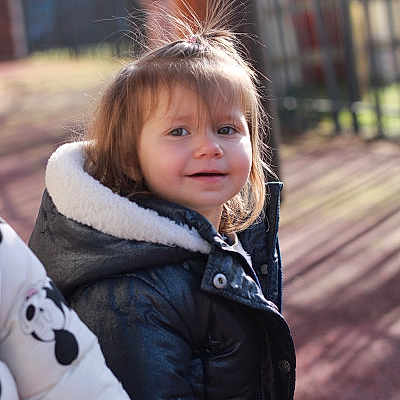 Lyanna participe au concours pour gagner de l'argent avec cette photo : child, outdoor, jacket, black_jacket, smile, hair, playground, sunlight, shadow, winter_clothing, curious, young_child, face, person, daylight, standing, cute, happy, warm_clothing, nature