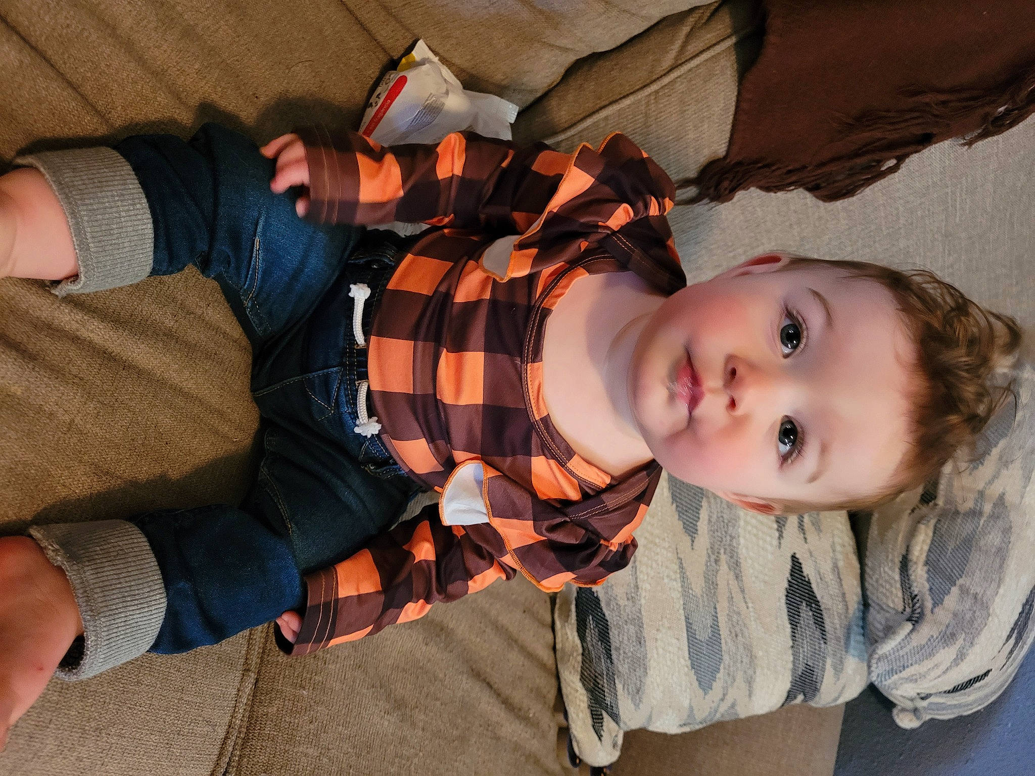 Blaine is registered to the contest to win money with this photo: baby, baby_toddler_clothing, child, comfort, elbow, fun, human_leg, orange, pattern, person, plaid, sitting, sleeve, sock, tartan, thigh, toddler, vacation, wood
