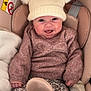 baby, smiling, hat, pom_poms, sweater, car_seat, child, infant, cozy, cute, happy, clothing, seatbelt, floral_pants, pink, warm, indoor, portrait, bundle_up, fuzzy