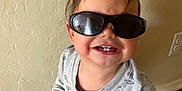 Damian joined the competition — help win amazing prizes! casual, child, cute, floor, food, gray_shirt, happy, indoor, long_sleeve, messy_hair, person, playful, red_sock, sandwich, smile, standing, sunglasses, teeth, toddler, wall