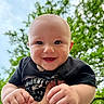 baby, child, smiling, happy, face, hands, outdoor, nature, greenery, sky, portrait, cute, infant, person, toddler, holding, black_shirt, daylight, closeup, joyful
