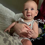 Kaysen is registered to the contest to win money with this photo: baby, child, infant, person, hand, face, blue_eyes, smile, blanket, clothing, indoor, cozy, cute, portrait, skin, sitting, holding, human, soft_light, young