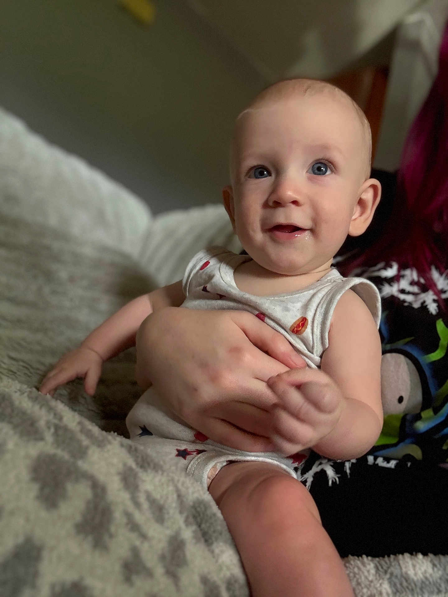 Kaysen is registered to the contest to win money with this photo: baby, child, infant, person, hand, face, blue_eyes, smile, blanket, clothing, indoor, cozy, cute, portrait, skin, sitting, holding, human, soft_light, young