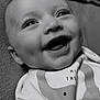 Theo is registered to the contest to win money with this photo: baby, smiling, face, close_up, black_and_white, infant, eyes, blanket, clothing, happy, cute, portrait, newborn, cheerful, child, soft_texture, lying_down, gentle_light, adorable, expression
