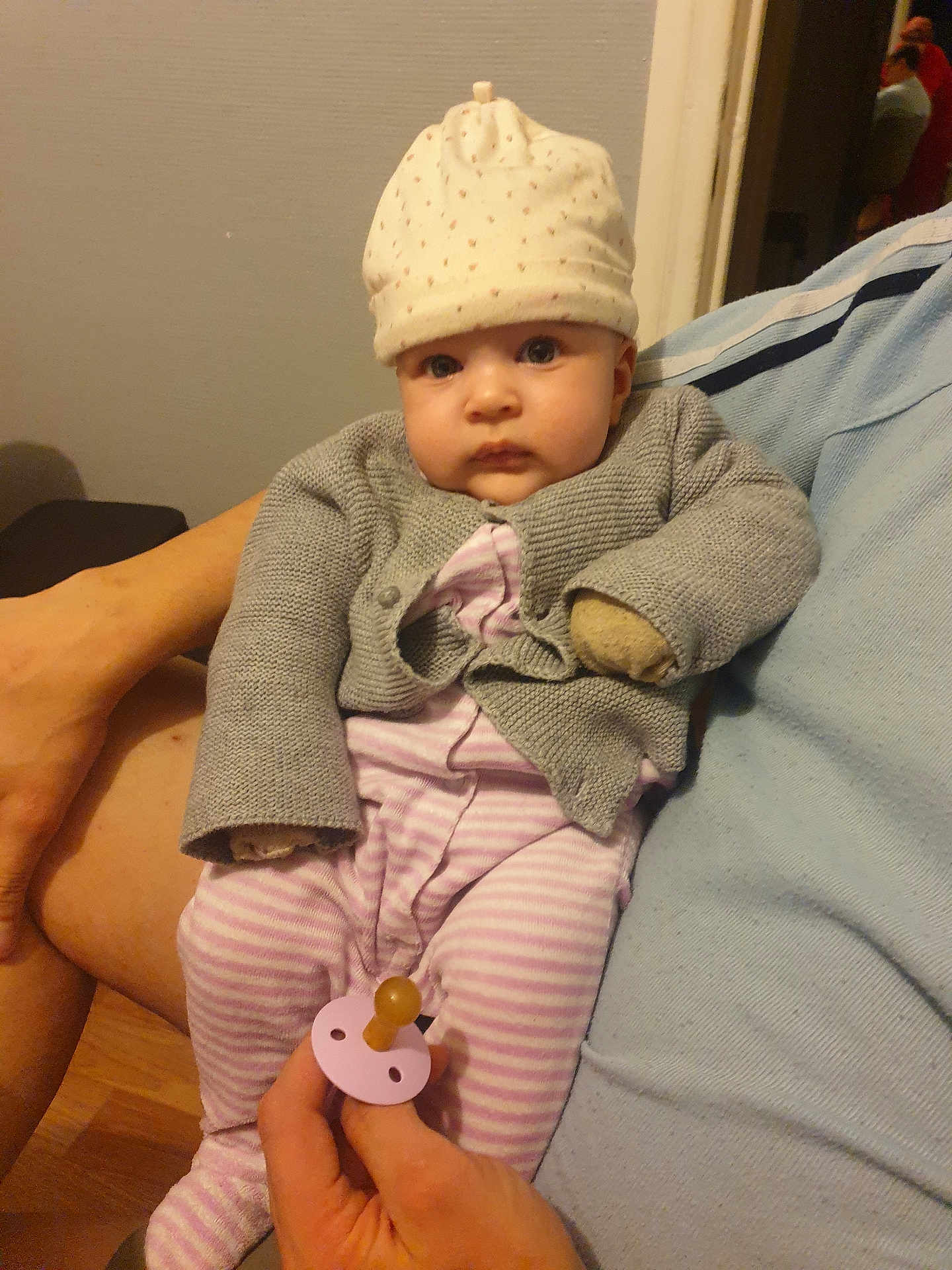 Louna a rejoint le concours — aidez-le/la à gagner de superbes lots ! baby, cardigan, child, clothing, comfort, cozy, cute, expressionless, face, hand, hat, holding, human, indoor, infant, pacifier, person, seated, skin, striped_pajamas