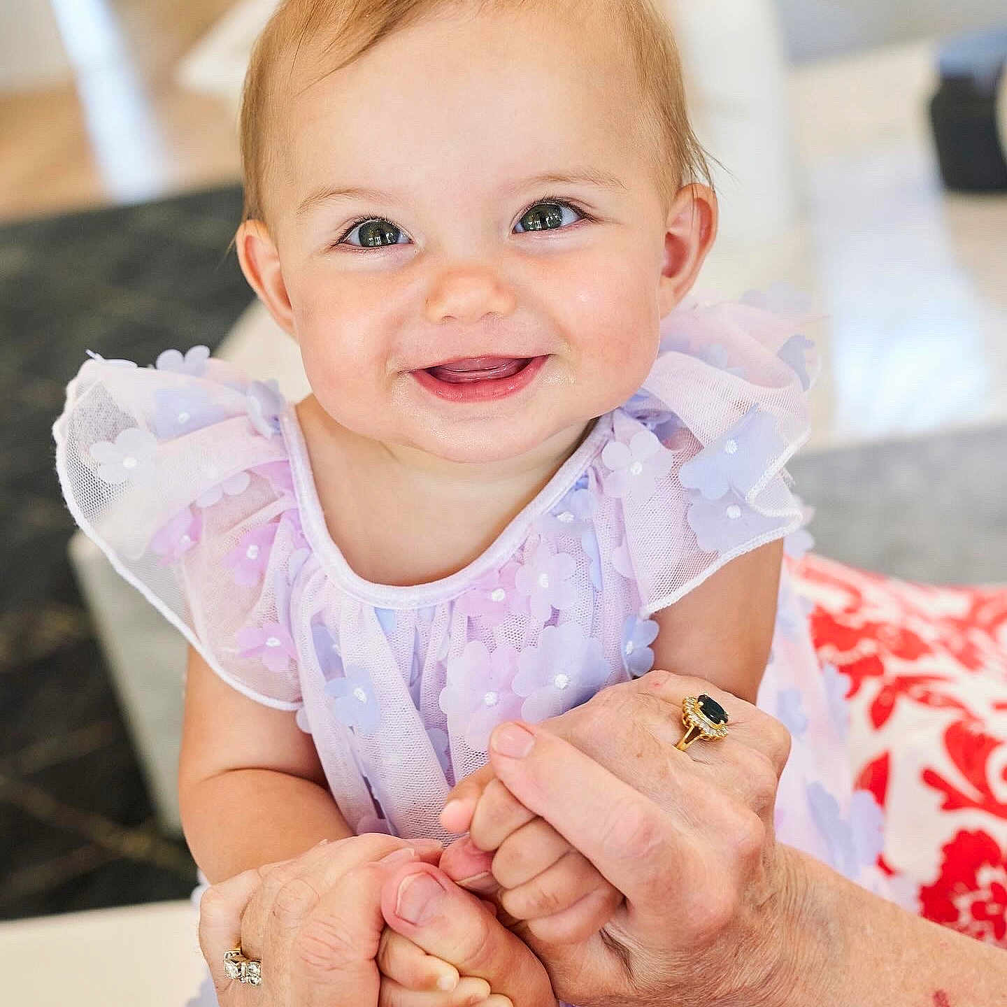 Sophie is registered to the contest to win money with this photo: baby, child, closeup, cute, dress, elderly_hands, face, family, flower_pattern, hands, happy, holding_hands, indoor, love, person, portrait, purple_dress, rings, skin, smiling