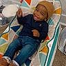 Noah is registered to the contest to win money with this photo: toddler, child, smiling, beanie, jeans, baby_rocker, indoor, carpet, happy, casual_clothing, footwear, person, colorful, seat, playful, young_child, cute, cheerful, baby, home