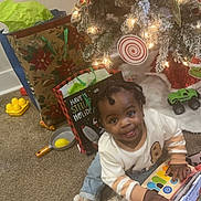Noah joined the competition — help win amazing prizes! toddler, child, christmas_tree, holiday, gift_bags, toys, carpet, indoor, smile, happy, slippers, sweater, piano_toy, decorations, lights, festive, playing, present, floor, home