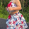 Katalina Correa is registered to the contest to win money with this photo: toddler, child, outdoor, dress, sandals, star_pattern, red_bow, pavement, greenery, trees, summer, cute, portrait, standing, fashion, young_child, nature, sunlight, casual, walking