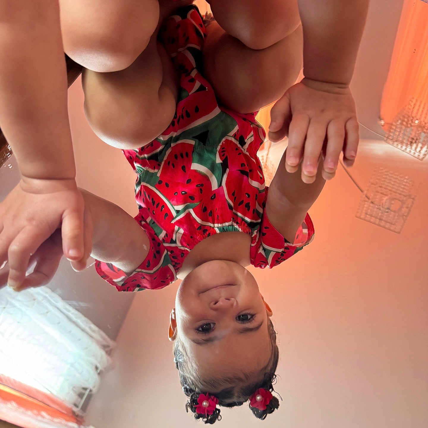 Katalina Correa is registered to the contest to win money with this photo: toddler, child, baby, face, hands, watermelon_outfit, curly_hair, hair_accessories, indoor, room, curtains, window, orange_wall, playful, cute, portrait, skin, expression, person, photography