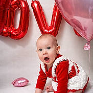 Bella joined the competition — help win amazing prizes! baby, infant, child, balloons, heart_balloon, red_balloon, pink_balloon, party, celebration, surprised_expression, crawling, hand, knit_dress, red_clothing, studio_backdrop, portrait, cute, big_eyes, floor, decorations