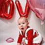 baby, infant, child, balloons, heart_balloon, red_balloon, pink_balloon, party, celebration, surprised_expression, crawling, hand, knit_dress, red_clothing, studio_backdrop, portrait, cute, big_eyes, floor, decorations