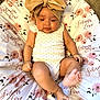 Soliana joined the competition — help win amazing prizes! baby, infant, headband, bow, floral_pattern, cushion, white_onesie, polka_dots, cute, chubby_cheeks, barefoot, lying_down, indoors, soft_lighting, child, portrait, adorable, resting, skin, young