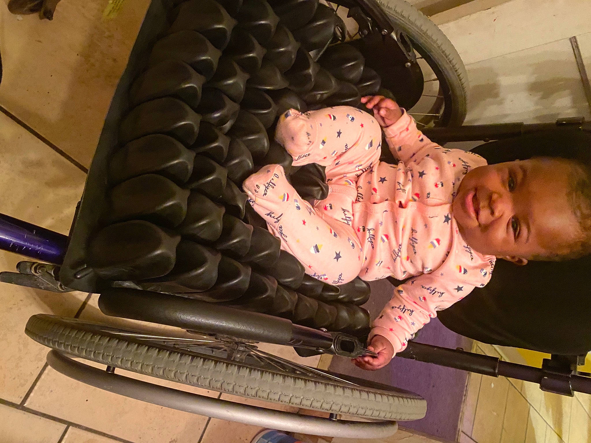 Khari is registered to the contest to win money with this photo: auto_part, automotive_design, automotive_exterior, automotive_tire, baby, baby_carriage, baby_products, baby_toddler_clothing, bumper, child, comfort, helmet, motor_vehicle, pattern, person, product, sitting, tire, toddler, vehicle