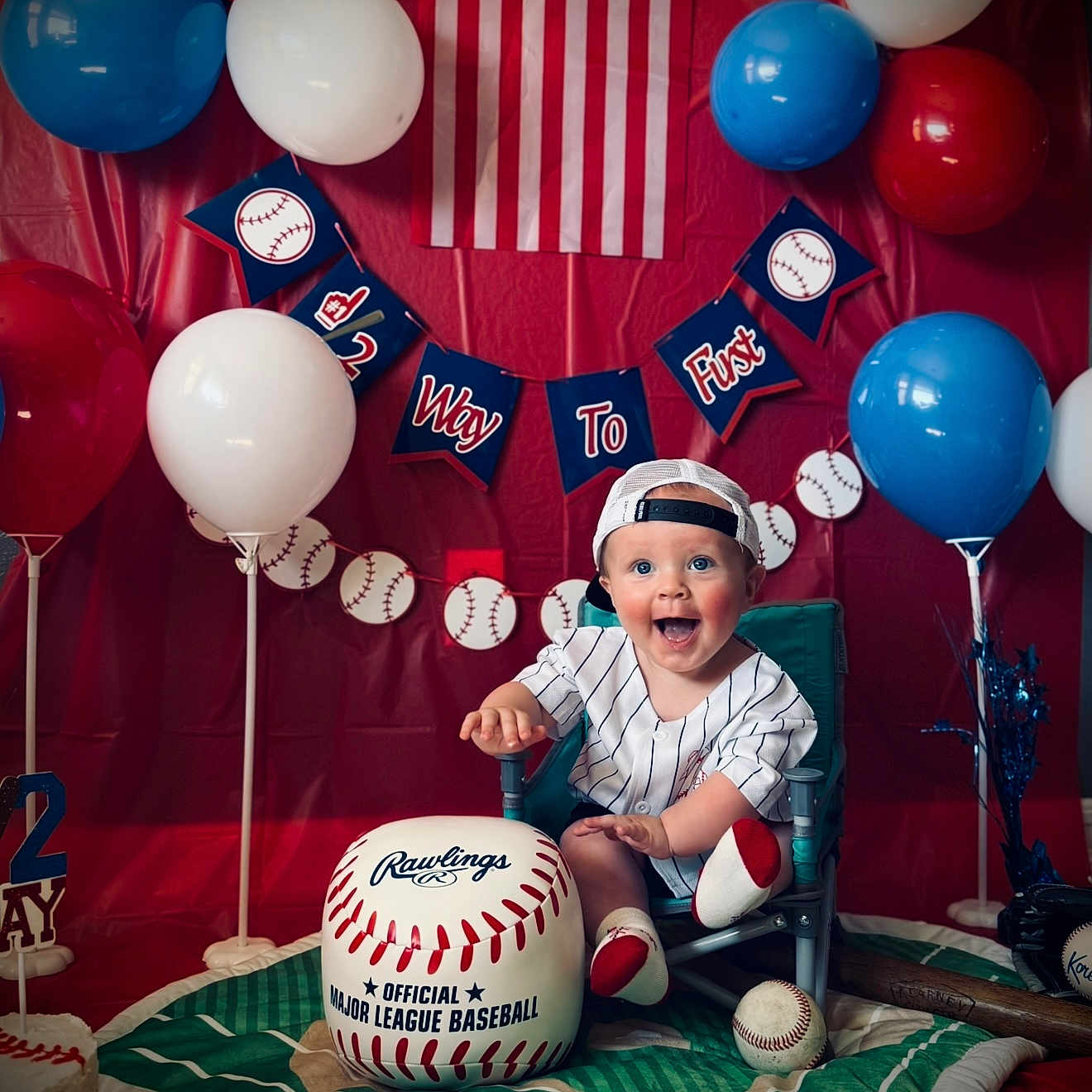 Cayson is registered to the contest to win money with this photo: baby, balloons, baseball, birthday, cap, celebration, chair, child, decorations, flag, happy, indoor, jersey, major_league_baseball, party, person, plush, sports, toy, young_child