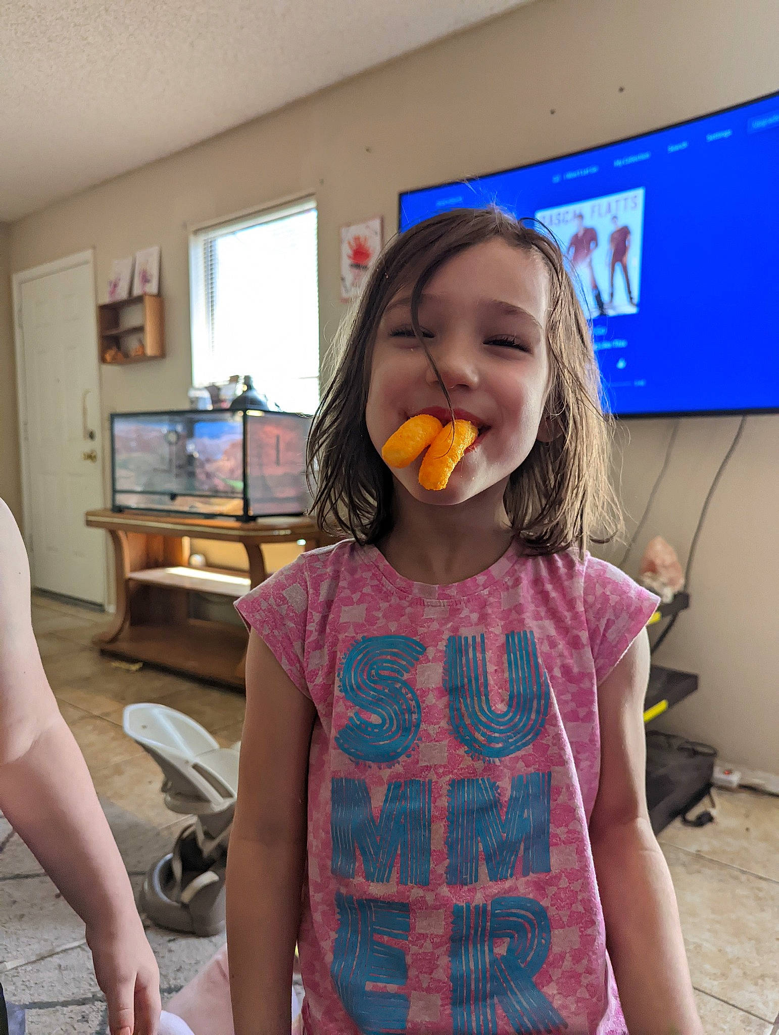 Emma is registered to the contest to win money with this photo: child, finger, fun, hairstyle, happy, jaw, joint, joy, long_hair, mouth, neck, pattern, person, picture_frame, play, sleeve, snapshot, t_shirt, thigh, thumb