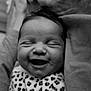 baby, smiling, close_up, black_and_white, infant, blanket, leopard_print, face, sleeping, cute, soft_texture, happy, newborn, portrait, child, cozy, resting, wrapped, head, peaceful