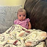 Chloe joined the competition — help win amazing prizes! baby, infant, blanket, couch, purple_clothing, polka_dots, face, indoor, child, seated, expression, cozy, soft_lighting, home, furniture, decor, head, skin, person, wrapped