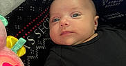 Chloe joined the competition — help win amazing prizes! baby, infant, black_clothing, plush_toy, pink, star, blanket, pattern, face, person, indoor, soft_toy, cute, child, young, resting, lying_down, expression, cozy, colorful
