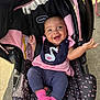 baby, car_seat, smiling, bib, pink_socks, outdoor, sunlight, clothing, happy, person, infant, seat, fabric, head, face, cute, child, casual, portrait, joy