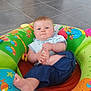 baby, child, infant, indoor, colorful, inflatable_seat, toy, foot, hand, blue_eyes, casual_clothing, floor_tiles, playtime, cute, expression, person, young_child, sitting, home, bright_colors