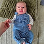 Rafael participe au concours pour gagner de l'argent avec cette photo : baby, child, blue_overalls, striped_clothing, cute, smiling, holding_hand, cushion, textured_rug, indoor, person, infant, happy, face, foot, hand, clothing, head, skin, comfort