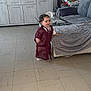 Wassim participe au concours pour gagner de l'argent avec cette photo : toddler, child, living_room, sofa, television, floor, glass_table, decor, curly_hair, traditional_clothing, maroon_outfit, cushion, cabinet, indoor, smiling, person, furniture, home, happy, curtains