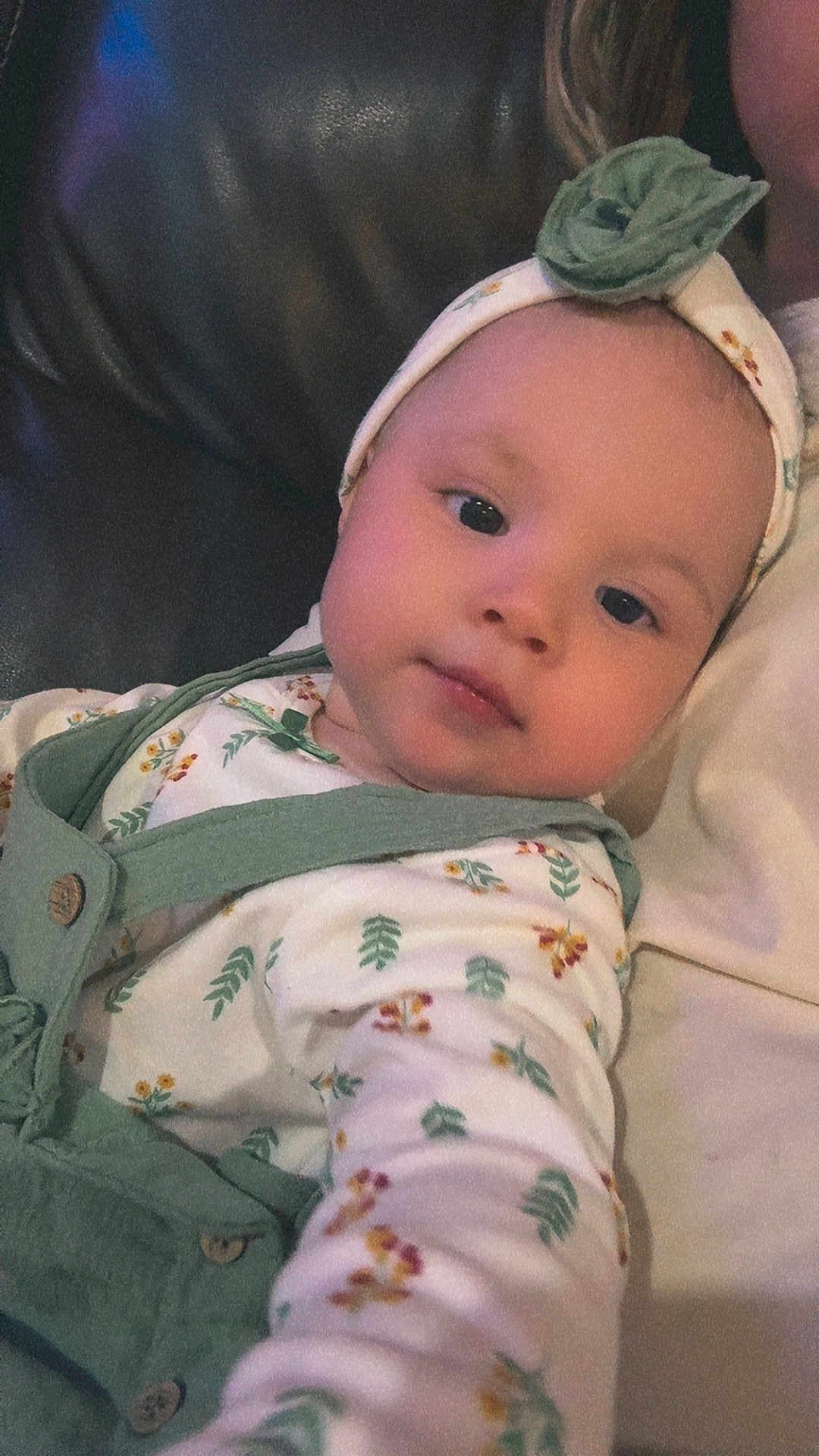 Ayla joined the competition — help win amazing prizes! baby, infant, headband, green_clothing, floral_pattern, couch, leather, portrait, child, young_child, face, eyes, indoor, person, cute, comfortable, relaxed, soft_lighting, closeup, apparel