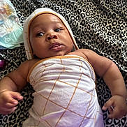 Tayden joined the competition — help win amazing prizes! baby, infant, towel, blanket, leopard_print, wrapped, skin, face, hand, lying_down, curious, eyes, lips, child, soft, comfortable, indoor, newborn, cute, young