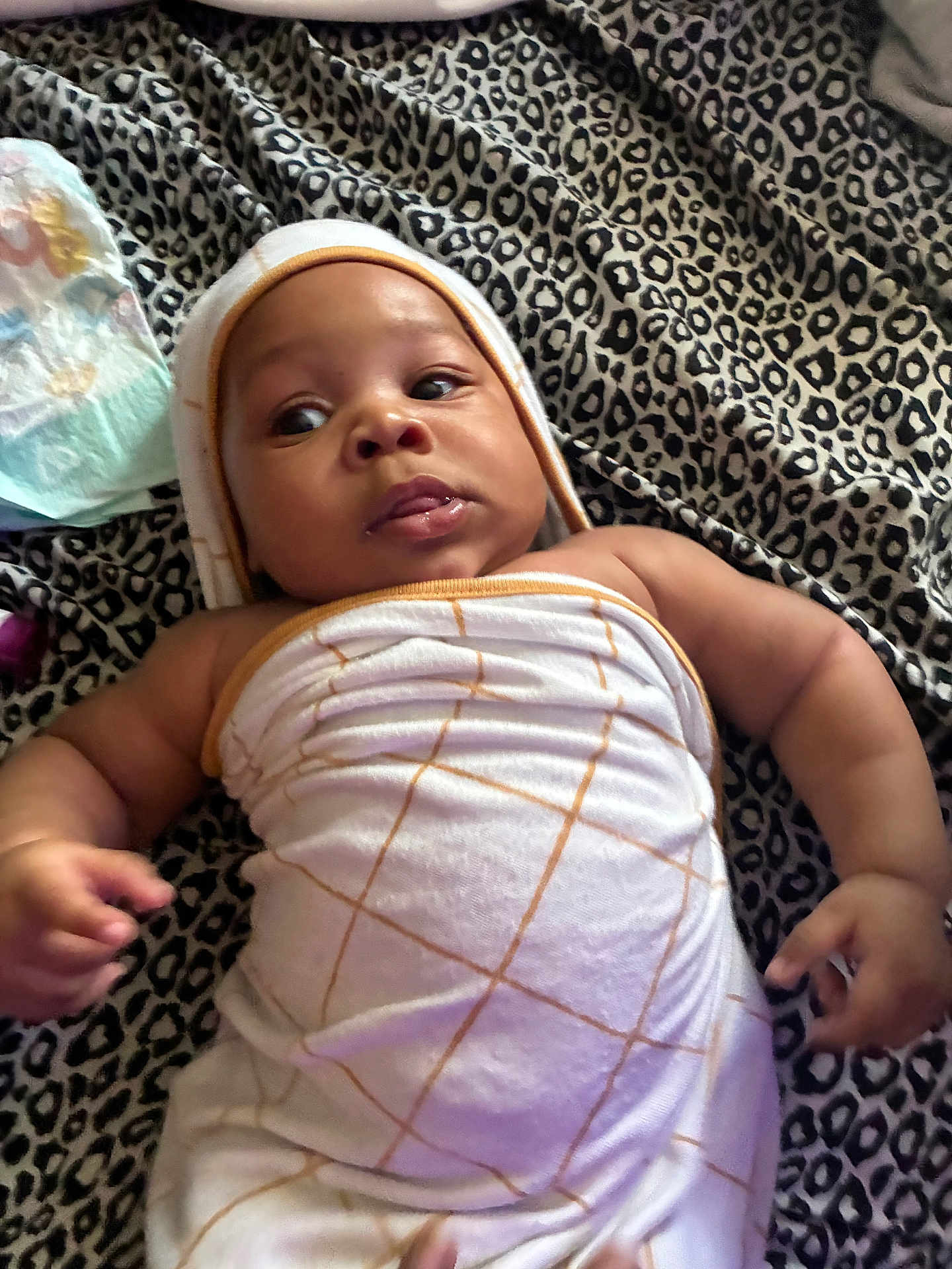 Tayden joined the competition — help win amazing prizes! baby, infant, towel, blanket, leopard_print, wrapped, skin, face, hand, lying_down, curious, eyes, lips, child, soft, comfortable, indoor, newborn, cute, young