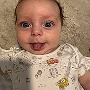 Leo joined the competition — help win amazing prizes! baby, tongue_out, onesie, cartoon_cars, blue_eyes, cute, infant, face, expression, skin, hair, carpet, soft_texture, lying_down, closeup, child, playful, smile, indoors, person