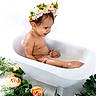 Massiel is registered to the contest to win money with this photo: baby, bathtub, child, cute, earrings, flower_crown, flowers, greenery, innocence, milk_bath, nature, peach_roses, portrait, relaxation, sitting, skin, studio_photo, toddler, water, white_background
