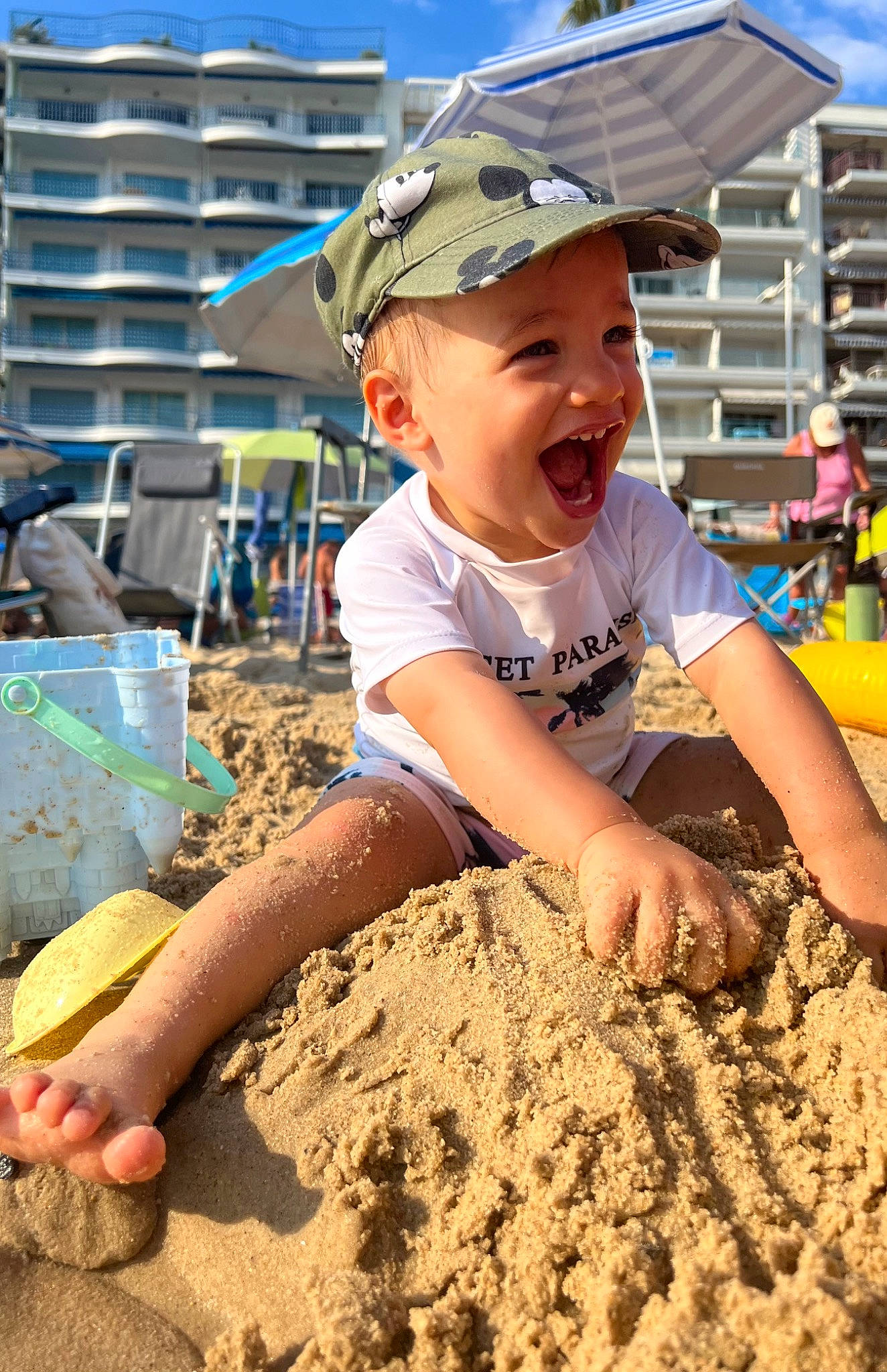 Cayden a rejoint le concours — aidez-le/la à gagner de superbes lots ! baseball_cap, beach, building, cap, child, cloud, fun, happy, hat, headwear, landscape, leisure, people_in_nature, person, recreation, sand, sky, smile, soil, summer