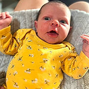 Victoire participe au concours pour gagner de l'argent avec cette photo : baby, infant, yellow_clothing, floral_pattern, blanket, soft_texture, face, eyes, mouth_open, hands, skin, person, cute, newborn, lying_down, indoor, portrait, expression, human, child