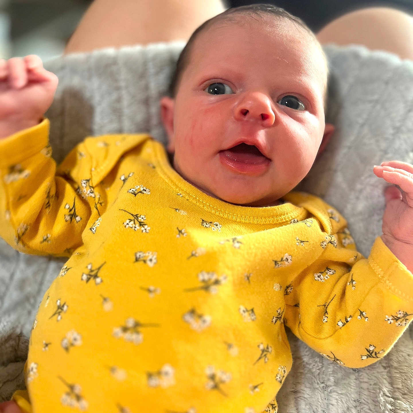 Victoire participe au concours pour gagner de l'argent avec cette photo : baby, blanket, child, cute, expression, eyes, face, floral_pattern, hands, human, indoor, infant, lying_down, mouth_open, newborn, person, portrait, skin, soft_texture, yellow_clothing