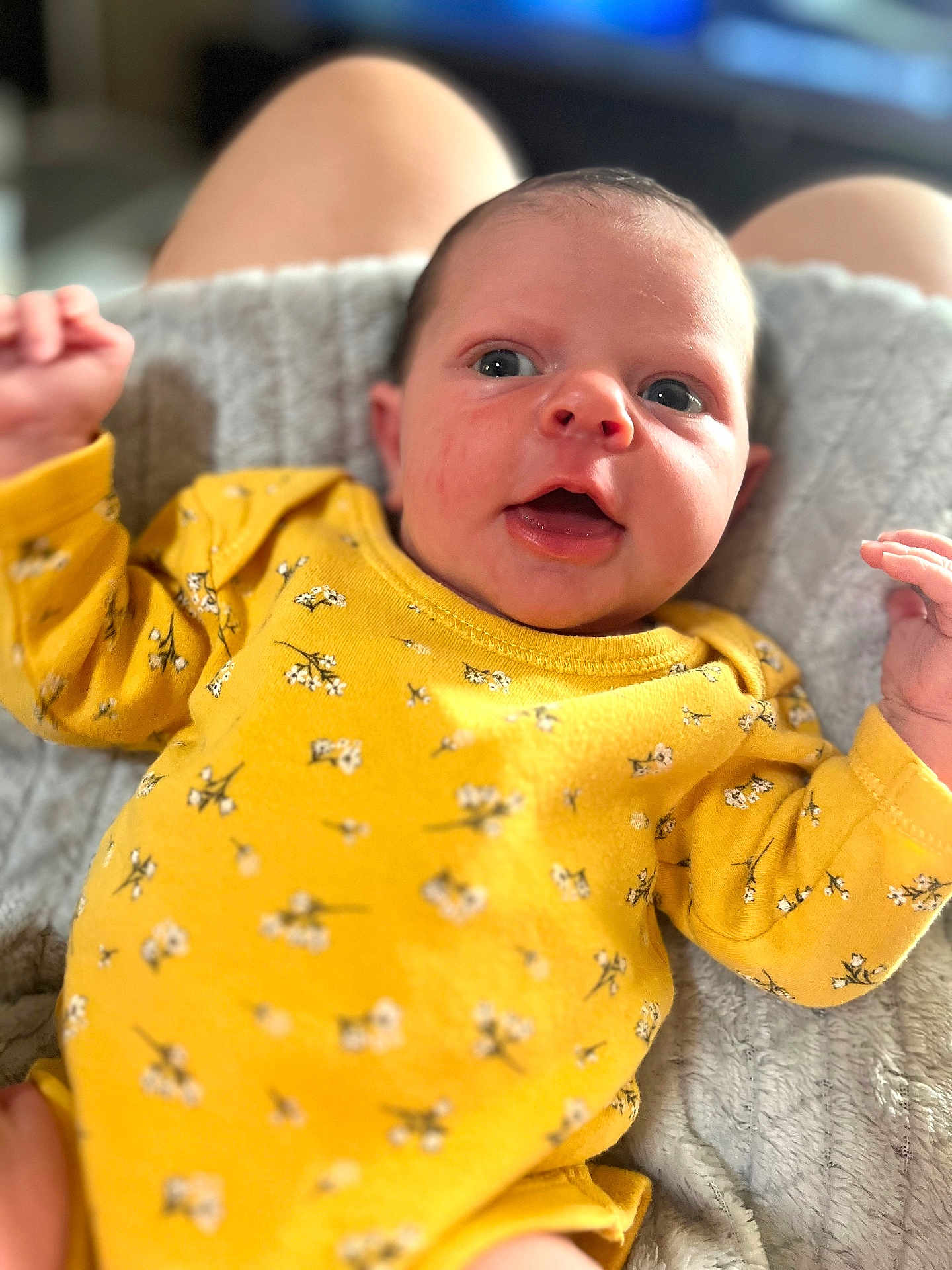 Victoire participe au concours pour gagner de l'argent avec cette photo : baby, infant, yellow_clothing, floral_pattern, blanket, soft_texture, face, eyes, mouth_open, hands, skin, person, cute, newborn, lying_down, indoor, portrait, expression, human, child
